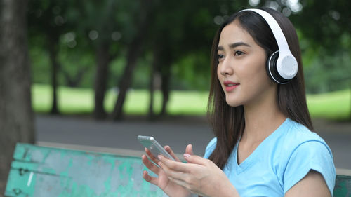 Portrait of young woman using mobile phone outdoors