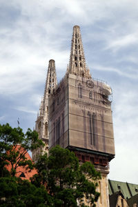 Low angle view of building and trees against sky