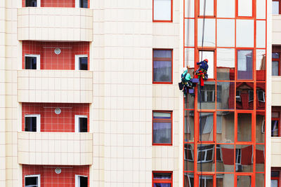 Window washing and cleaning service . workers hanging on the ropes and washing windows