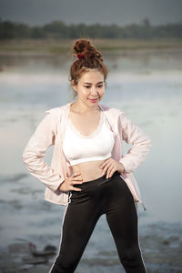 Young woman holding smart phone while standing in lake