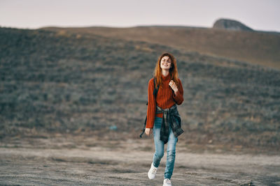 Portrait of young woman standing on land