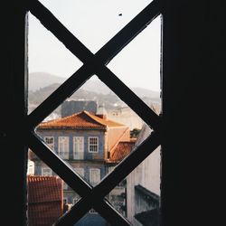 Close-up of buildings against sky seen through window