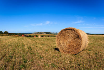 Hay bales on field against sky