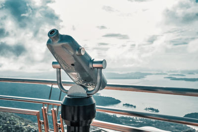 Coin-operated binoculars at observation point against sky
