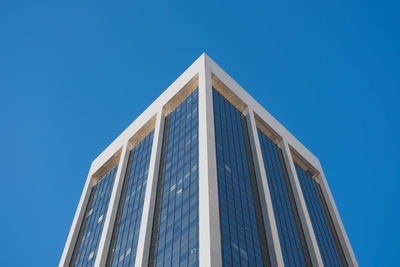 Low angle view of modern office building against clear blue sky