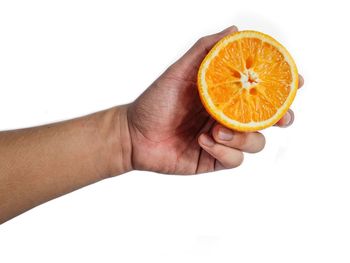 Cropped image of hand holding apple against white background