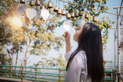 Portrait of young woman photographing through smart phone