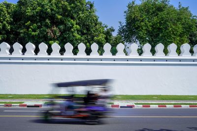 Blurred motion of people on road against sky