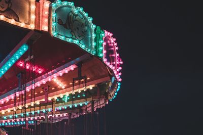 Low angle view of illuminated ferris wheel against sky at night