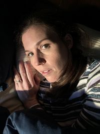 High angle portrait of woman lying in darkroom