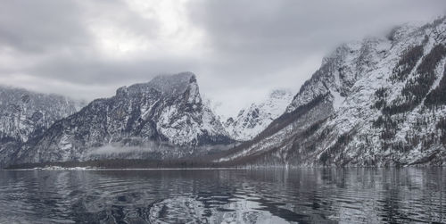 Scenic view of lake by mountains against sky