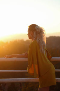 Backlighting portrait of beautiful woman in yellow dress at spring wedding with sunset light