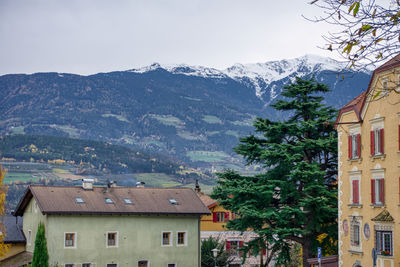 Houses by trees and mountains against sky