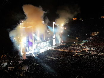 Crowd at illuminated city during night