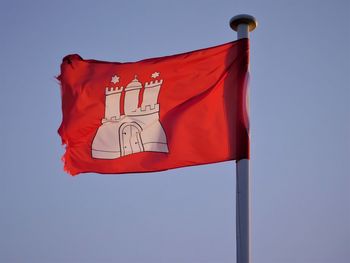 Low angle view of flag against blue sky