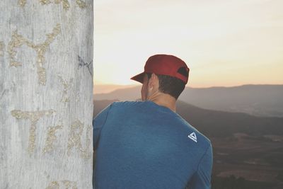 Rear view of man standing against sky during sunset