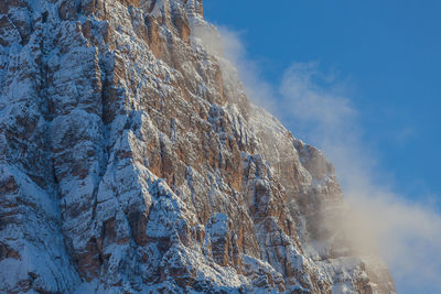 Clouds on mount pelmo slope during a winter sunset, dolomites, italy