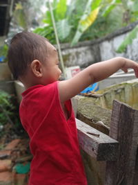 Side view of cute boy standing on wood