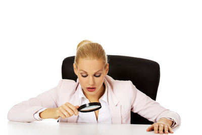 Mid adult woman sitting against white background