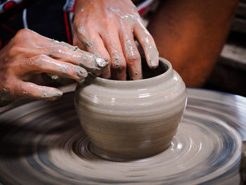 Cropped hands of man making pottery in workshop