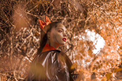 Close-up of young woman against tree
