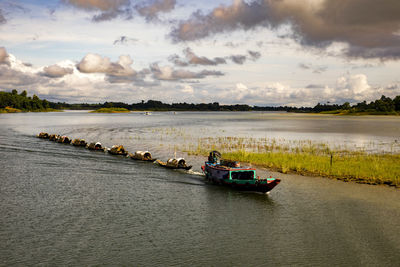 Boats sailing in river against sky