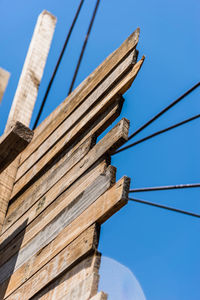 Low angle view of telephone pole against blue sky