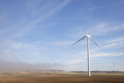 Windmill on field against sky