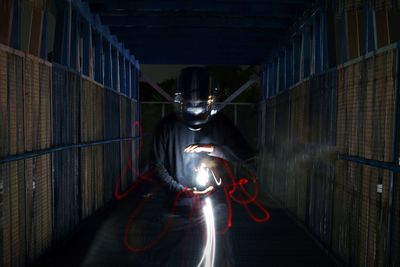 Worker with light painting in darkroom
