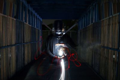 Worker with light painting in darkroom