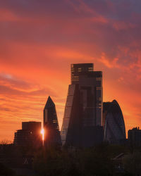 Low angle view of buildings against orange sky