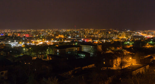 Illuminated cityscape against sky at night