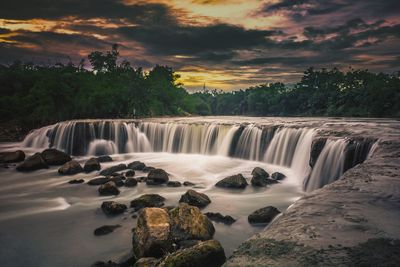Scenic view of waterfall against sky