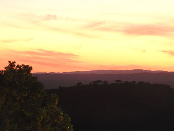 Scenic view of silhouette mountains against orange sky