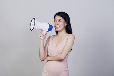 Young woman smiling against white background