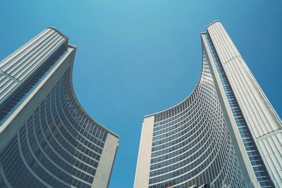 Low angle view of modern buildings against clear blue sky