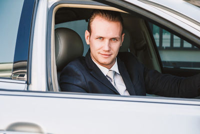Portrait of businessman driving car