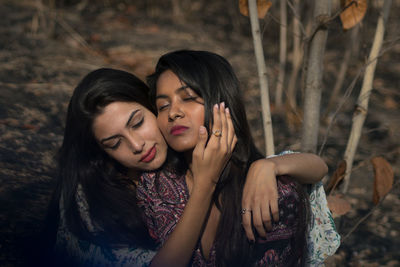 Lesbian couple romancing in forest 