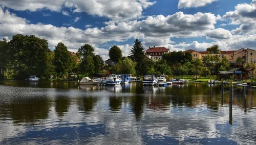 Sailboats moored in lake against sky