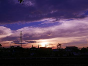 Silhouette electricity pylon against sky during sunset