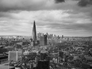 High angle view of buildings in city against cloudy sky