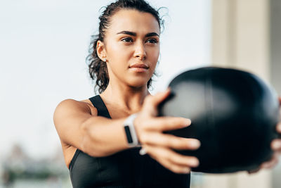 Close-up of woman holding fitness ball while exercising outdoors