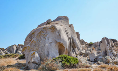 Low angle view of rock formations against clear blue sky