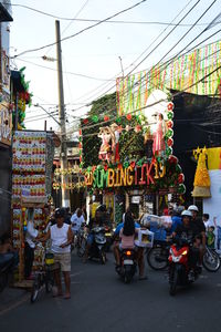 People on street against buildings in city