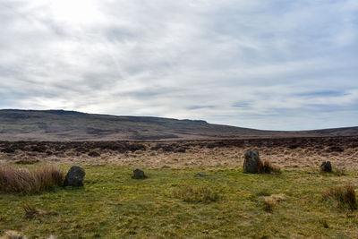 Hay bales on field against sky