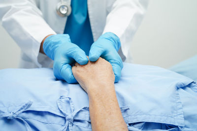 Midsection of doctor examining patient in hospital