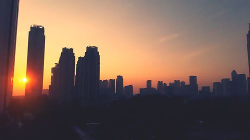 Silhouette buildings against sky during sunset