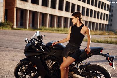 Side view of woman riding motorcycle on road
