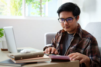 Young man using laptop at home office