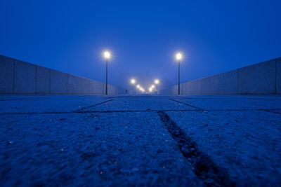 Surface level of street lights against blue sky at night